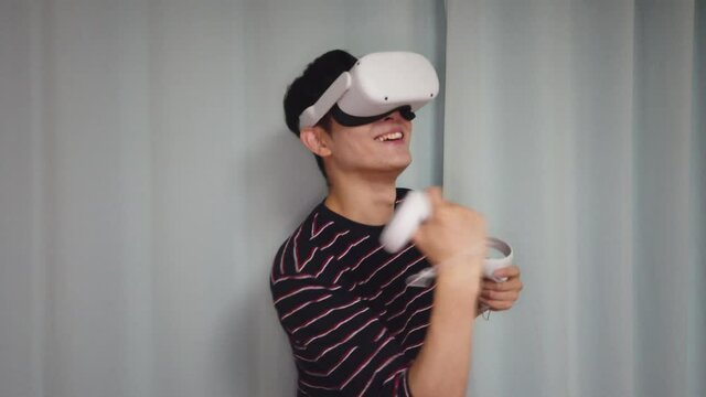 A young Korean male playing game using a virtual reality headset and controllers in 4K