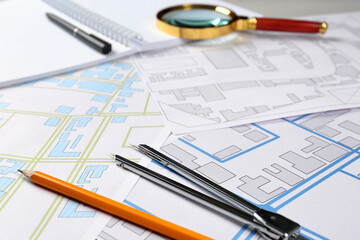 Office stationery and cadastral maps of territory with buildings on table