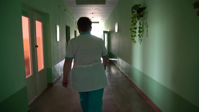 Health Care Worker Running Down A Hospital Corridor. Sloumo	