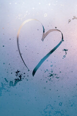 the inscription heart on frosty misted glass, delicate outline of the heart as a symbol of romantic love, vertical frame in pastel blue and pink with sun glare