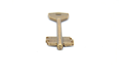 Vintage key on white background close-up. Texture, background, old, macro, wallpaper, metal, brass