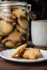 plato y frasco de cristal con galletas y taza de café 