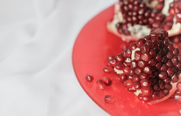 pomegranate on a red plate on a table. partial view. antioxidant food for longevity and heart health vegan food.