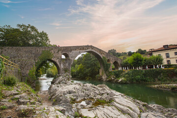 Fototapeta na wymiar Old Roman stone bridge in Cangas de Onis (Asturias), Spain in a sunny day