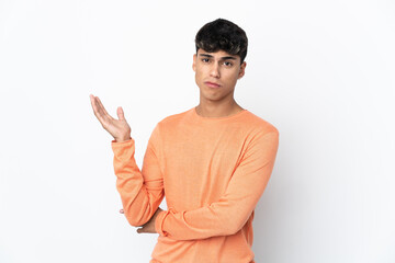 Young man over isolated white background having doubts