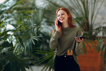 Home gardening concept. Young woman plants floral in greenhouse