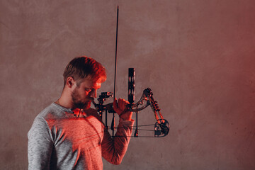 Archer man with modern block sport bow and arrow.
