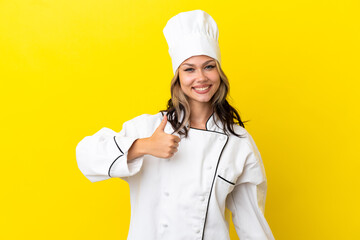 Young Russian chef girl isolated on yellow background giving a thumbs up gesture