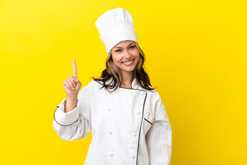 Young Russian chef girl isolated on yellow background showing and lifting a finger in sign of the best