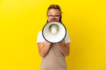 Restaurant waiter Russian girl isolated on yellow background shouting through a megaphone