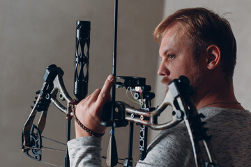 Archer man with modern block sport bow and arrow.