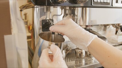 chef's hands steaming milk in coffee