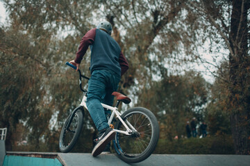 Fototapeta premium Professional young sportsman cyclist with bmx bike at skatepark