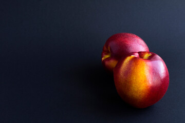 Fototapeta na wymiar Close-up on ripe nectarine on the black background. Copy space.