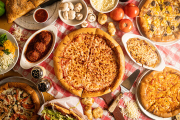 Pizza and baked italian dishes laid out on table