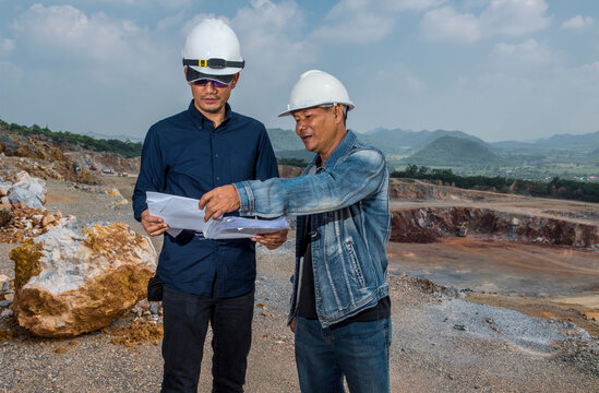 engineers discussing survey plan at gravel mine in Thailand