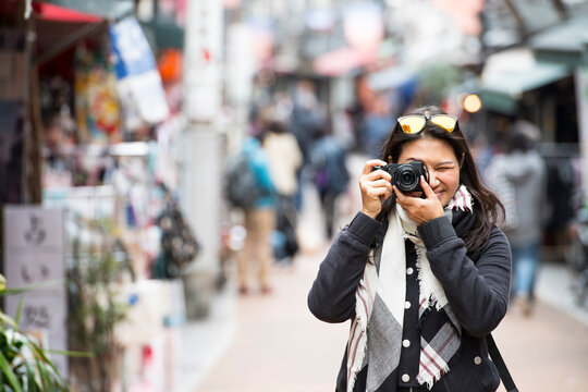 woman taking a picture with digital mirrorless camera in Tokyo