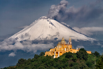 Morning view of church and a volcano behind with snow