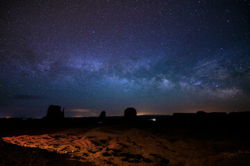 The Milky Way and night sky rises above Monument Valley in Arizona. © Cavan