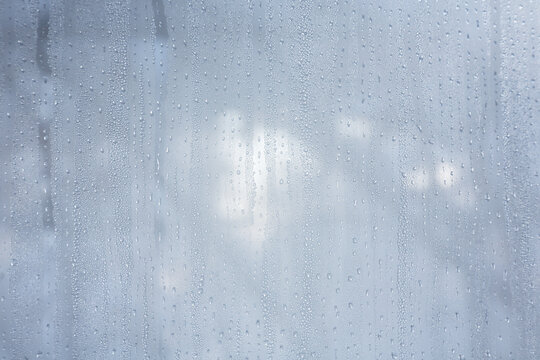 water drops on the fogged glass in the house against the background of winter