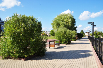 Panoramic view of the Desna river embankment. Paving stones, paving stones and rest benches. Summer day.