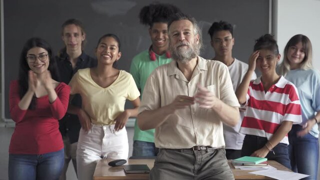 Positive Multi-ethnic group of teenager secondary school students and friendly teacher in the classroom of the smiling and clapping hands celebrating success. Cultural Diversity in Education