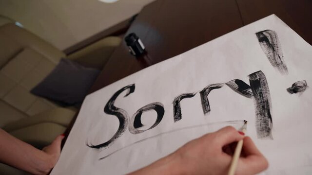 blonde woman in sexy swimsuit is writing sorry on sheet in cabin of plane