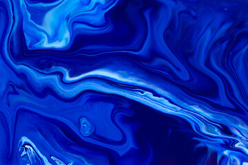 Obraz premium Fluid art texture. Backdrop with abstract mixing paint effect. Liquid acrylic picture that flows and splashes. Classic blue color of the year 2020. Blue, white and indigo overflowing colors.