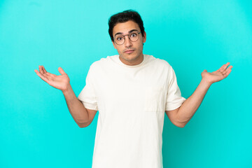 Fototapeta premium Caucasian handsome man over isolated blue background making doubts gesture