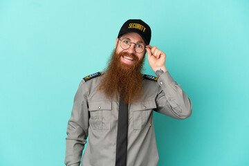Redhead security man isolated on white background with glasses and happy