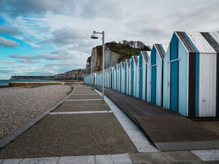 Blue and black beach huts on the pebble beach of Yport, Normandy,  France