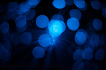 Blue abstract particles and lines with bokeh and blur in dark background.