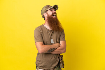 Redhead Military man with dog tag isolated on yellow background happy and smiling