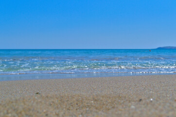 Blue sea and sandy beach as a blurry background for text.