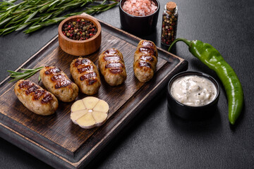Grilled sausage with the addition of herbs and vegetables on the dark background