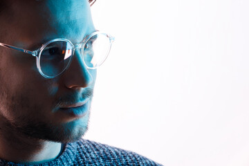 Male in glasses with futuristic holographic interface to display data. Portrait of beautiful young man. Augmented reality, future technology, internet concept.