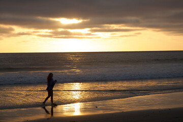 Girl Walking on beach at Sunset