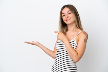 Young Romanian woman isolated on white background holding copyspace imaginary on the palm to insert an ad
