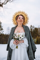 The bride is standing in a snow-covered forest. The bride in a fabulous protective mask. Above the...