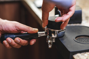 barista prensando café molido e el porta filtro