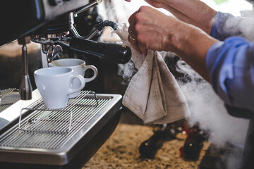 barista dando mantenimiento de limpieza a maquina para hacer café