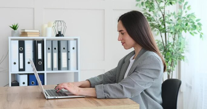 Businesswoman feeling grateful on receiving good news using laptop at office