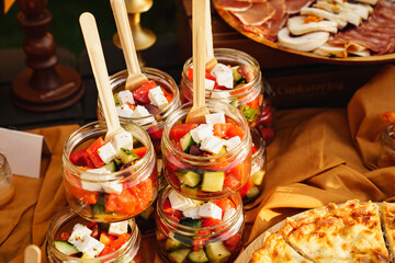 Greek salad in small glass jars at a banquet. catering 