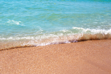 The sea wave runs over the sand. Summer vacation, travel and tourism.