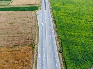 Aerial view of the road  between agricultural fields in Europe. Beautiful landscape. Captured from above with a drone