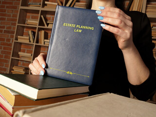  ESTATE PLANNING LAW book in the hands of a attorney. Estate planning is the process of...
