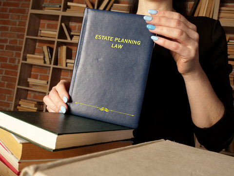  ESTATE PLANNING LAW book in the hands of a attorney. Estate planning is the process of anticipating and arranging, during a person's life