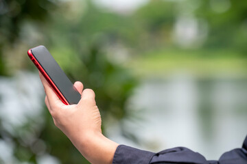 Man Hand hands holding smart phone blur nature background, people use smart phone for contact education, online marketing, business, online technology.