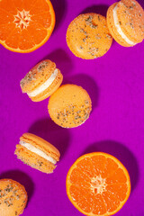Orange homemade macarons isolated on a bright purple background