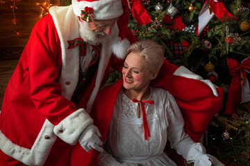 Santa Claus and wife Mrs. Claus near fireplace